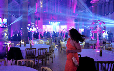 Gorton Monastery Manchester Event Lighting Multi Blue moving beams with gobos LED TV's on stands, arches lit with colour wash and a happy lady swinging her hair to music