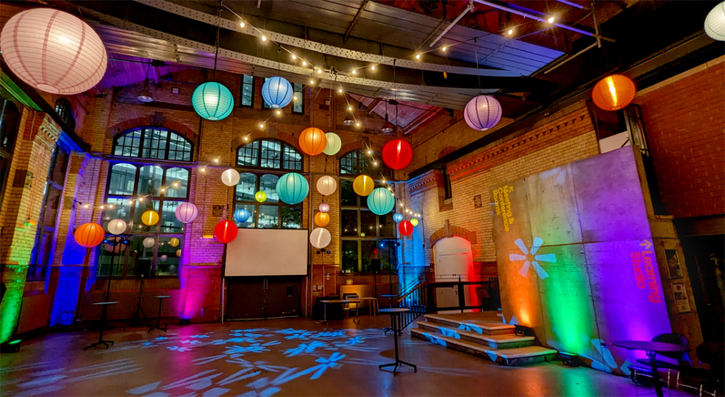 A wedding venue with an instalaltion of festoon lighting, chinese lanterns, disco effects lighting and LED uplights.