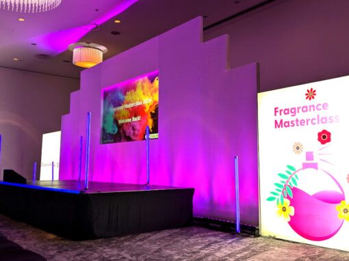 Stage and set for a conference with lighting and Astera tubes. There is a projection in the centre of the stage set.