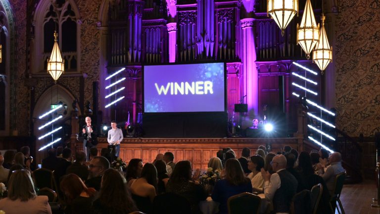 Awards show at Rochdale Town Hall with a lit organ and LED pixel tubes flanking a large projection screen